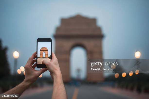 traveler photographing through mobile phone india gate - new delhi india gate stock pictures, royalty-free photos & images