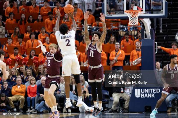 Hayden Hefner and Andersson Garcia of the Texas A&M Aggies defend a shot by Reece Beekman of the Virginia Cavaliers in the first half during a game...