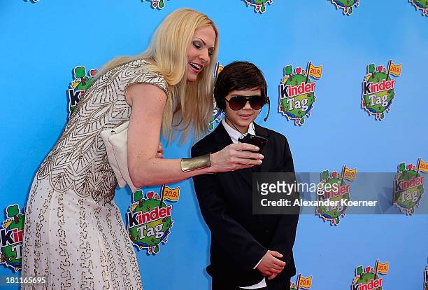 German TV presenter Sonya Kraus shows here to a security guy, which she took a photo with, during the red carpet prior the Ferrero kinderTag 2013...