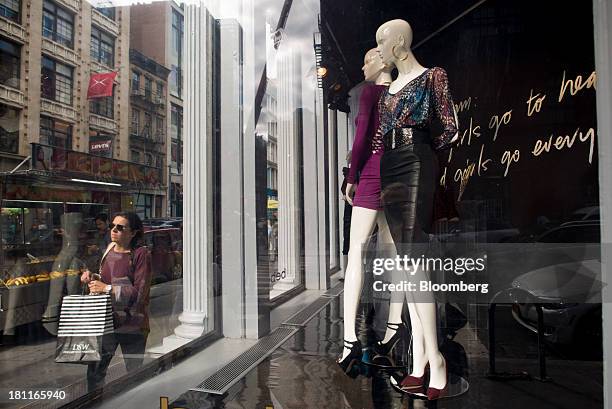 Pedestrians walk past mannequins in the window of a Bebe Stores Inc. Shop in the shopping district of Soho in New York, U.S., on Saturday, Sept. 14,...