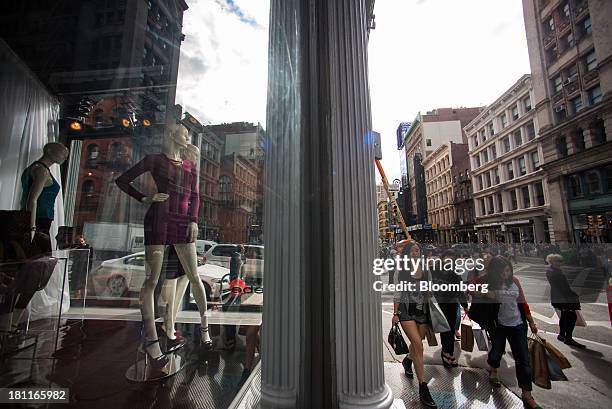 Pedestrians walk past mannequins in the window of a Bebe Stores Inc. Shop in the shopping district of Soho in New York, U.S., on Saturday, Sept. 14,...