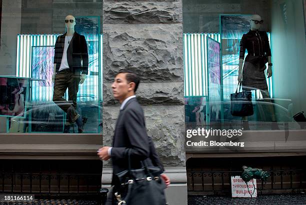 Pedestrian walks past mannequins in the window of a Diesel store in the shopping district of Soho in New York, U.S., on Saturday, Sept. 14, 2013....