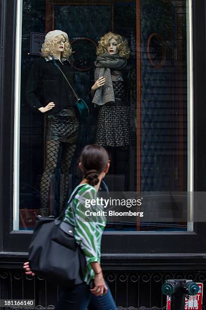 Shopper looks at a display in the window of a Chanel SA store in the shopping district of Soho in New York, U.S., on Saturday, Sept. 14, 2013....