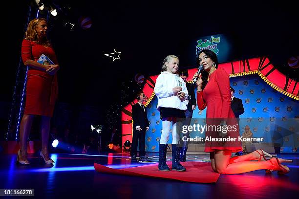 Barbara Schoeneberger, Verona Pooth and twelve year-old Naima are seen on stage during the Ferrero kinderTag 2013 event at Heidepark on September 19,...