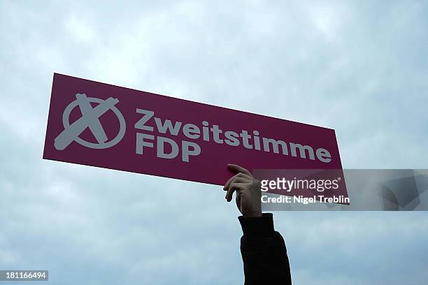 Supporter of German Free Democrats holds up a banner reading "Zweitstimme FDP" at a party's election campaign on September 19, 2013 in Hanover,...