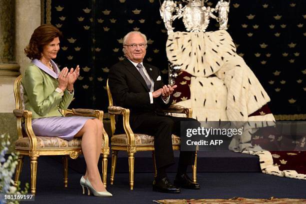 Sweden's King Carl Gustaf XVI and Queen Silvia sit next to the Queen's silver throne during a reception at the Royal Palace September 19, 2013 in...