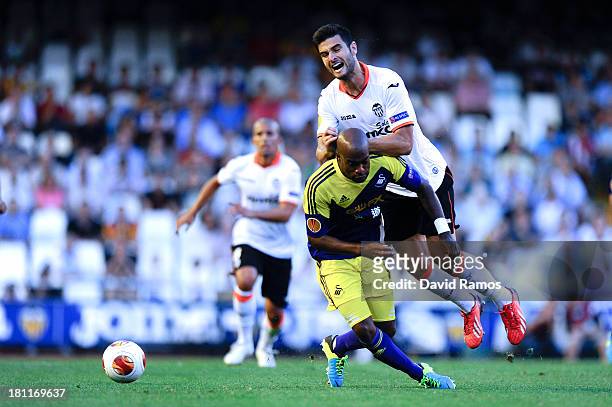 Dwight Tiendalli of Swansea City duels for the ball with Antonio Barragan of Valencia CF the UEFA Europa League Group A match between Valencia CF and...