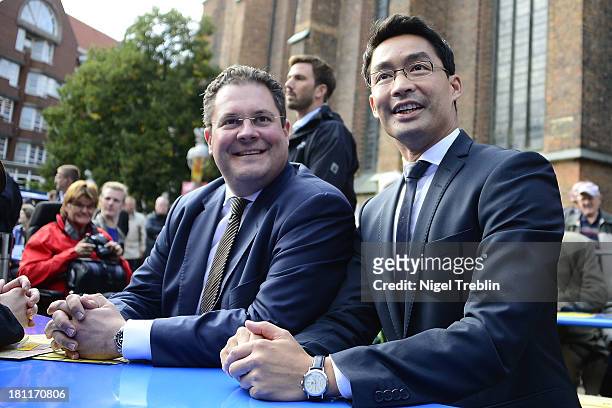 German Free Democrats party chairman Philipp Roesler and secretary general Patrick Doering sit together at a party's election campaign on September...