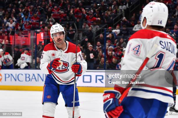 Alex Newhook of the Montreal Canadiens celebrates his second period goal with teammate Nick Suzuki of the Montreal Canadiens during a game against...