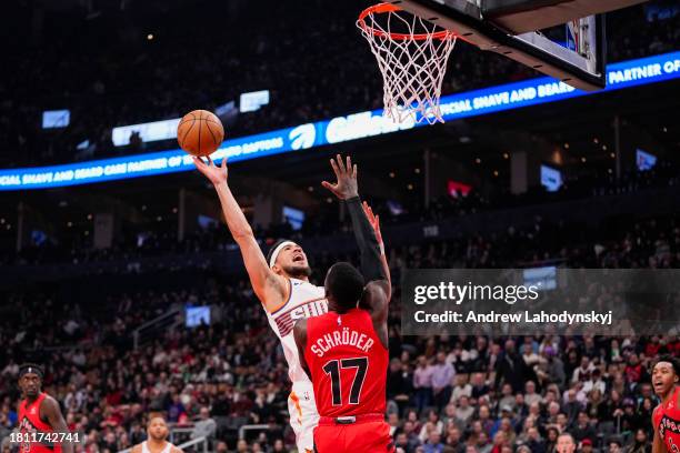 Devin Booker of the Phoenix Suns goes to the basket Agustin Dennis Schroder of the Toronto Raptors during first half action at the Scotiabank Arena...