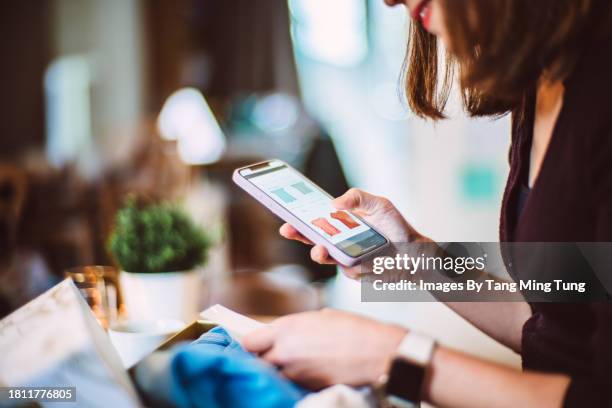 young woman doing online shopping for clothes on smartphone at home - accro du shopping photos et images de collection