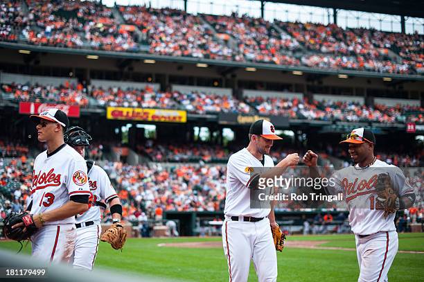 Alexi Casilla of the Baltimore Orioles high fives a teammate during the game /D? at Oriole Park at Camden Yards on June 2, 2013 in Baltimore,...
