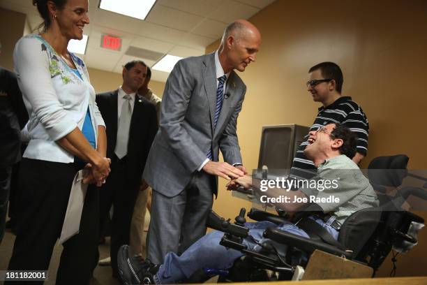 Florida Governor Rick Scott greets Scott Dorfman as he arrives for a town hall meeting with the Agency for Persons with Disabilities at the Spelios...