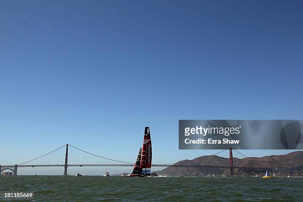Emirates Team New Zealand skippered by Dean Barker sails by the Golden Gate Bridge before race 12 against Oracle Team USA in the America's Cup Finals...
