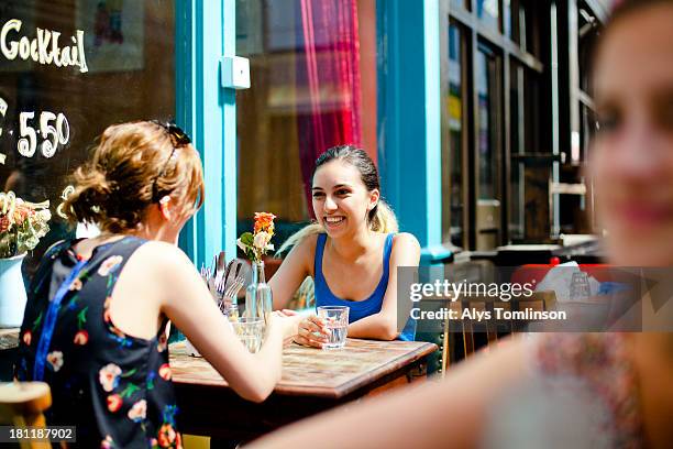 two girls at a cafe outdoors - café esplanada imagens e fotografias de stock