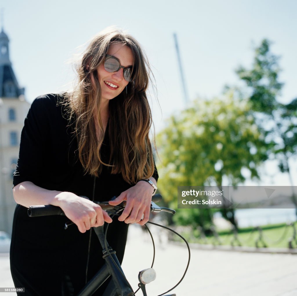 Portrait of a woman, standing by bicycle