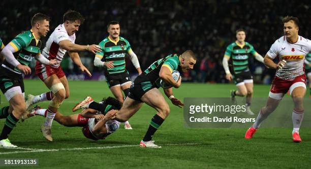 Ollie Sleightholme of Northampton Saints goes past Marcus Smith to score their first try during the Gallagher Premiership Rugby match between...
