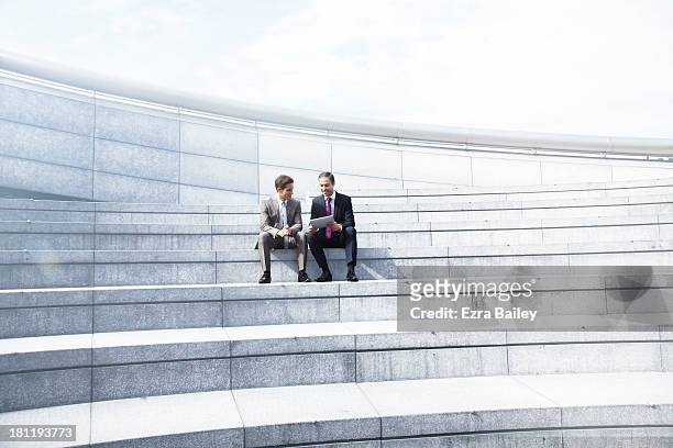 two businessmen working in a tablet. - 2 steps stock-fotos und bilder
