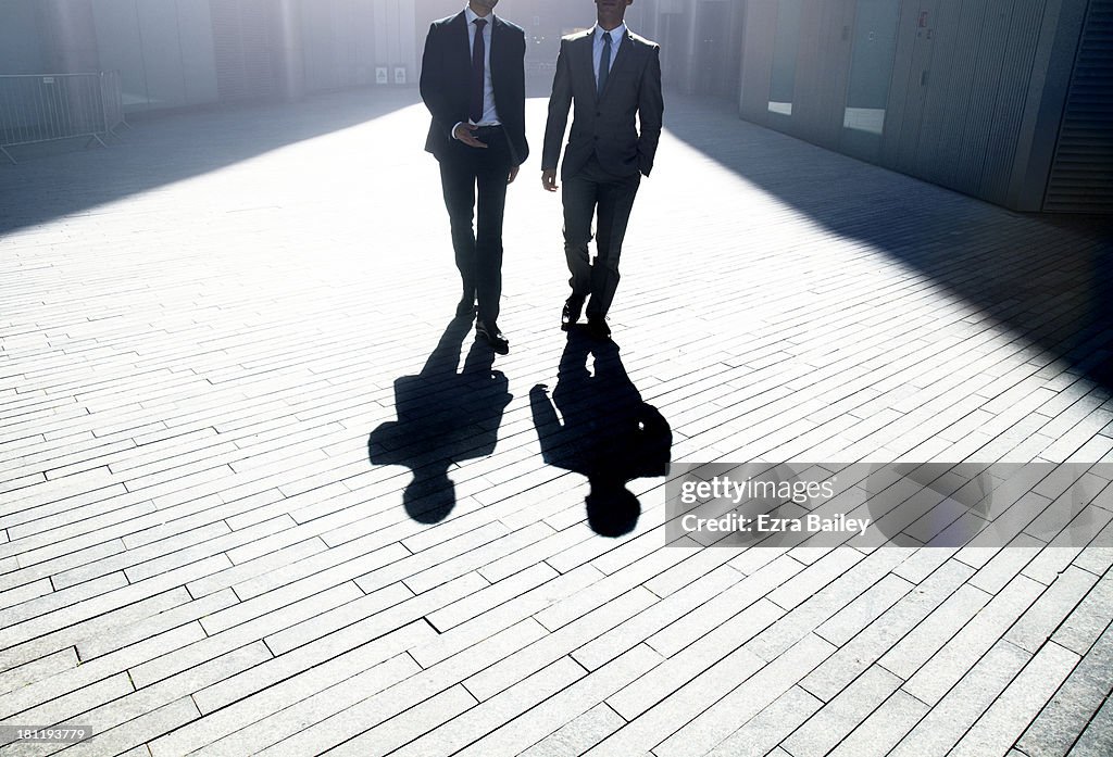 Two businessmen walking through the city.