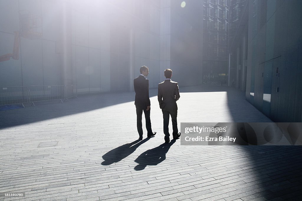 Two businessmen walking through the city.