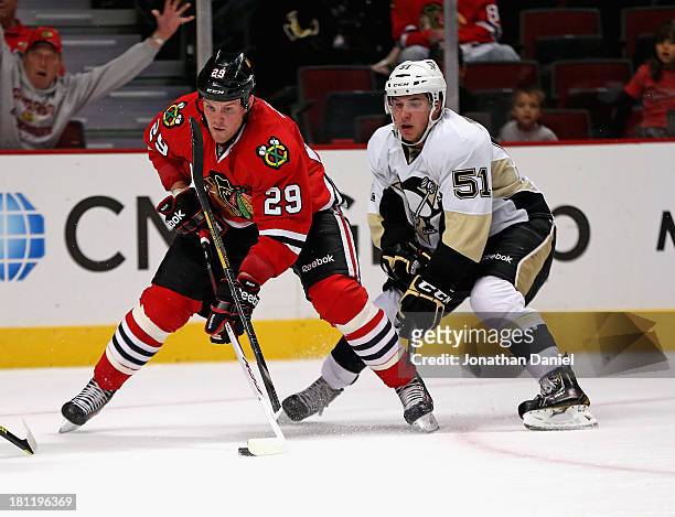 Bryan Bickell of the Chicago Blackhawks tries to get off a shot after Derrick Pouliot of the Pittsburgh Penguins breaks his stick trying for a block...