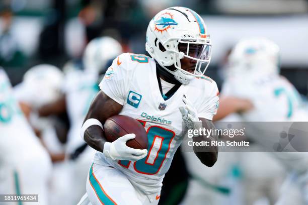 Tyreek Hill of the Miami Dolphins runs with the ball after a catch against the New York Jets during the first quarter in the game at MetLife Stadium...