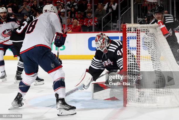 Boone Jenner of the Columbus Blue Jackets gets the puck past Akira Schmid of the New Jersey Devils during the first period at Prudential Center on...