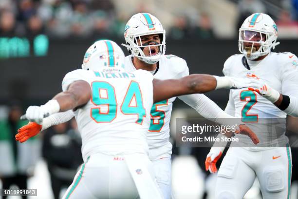 Jaelan Phillips of the Miami Dolphins celebrates with Christian Wilkins after making a defensive stop against the New York Jets during the first...
