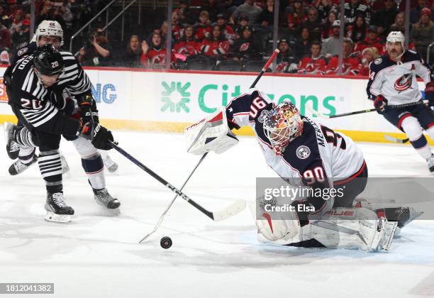 Elvis Merzlikins of the Columbus Blue Jackets stops a shot by Michael McLeod of the New Jersey Devils during the second period at Prudential Center...