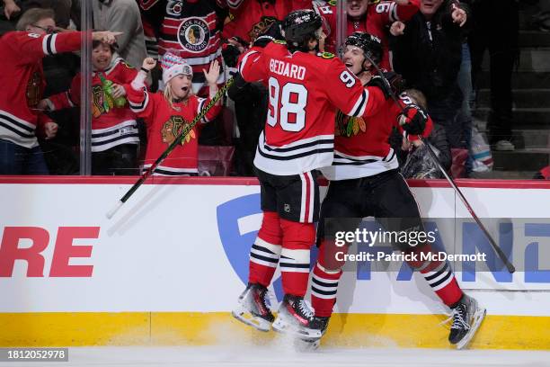Kevin Korchinski of the Chicago Blackhawks celebrates with teammate Connor Bedard after scoring the game winning goal against the Toronto Maple Leafs...