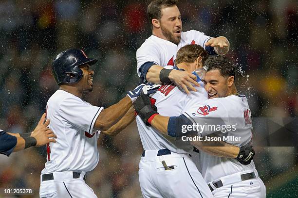 Teammates Michael Bourn Jason Kipnis and Mike Aviles celebrate with Matt Carson of the Cleveland Indians after Carson hit a walk-off RBI single...