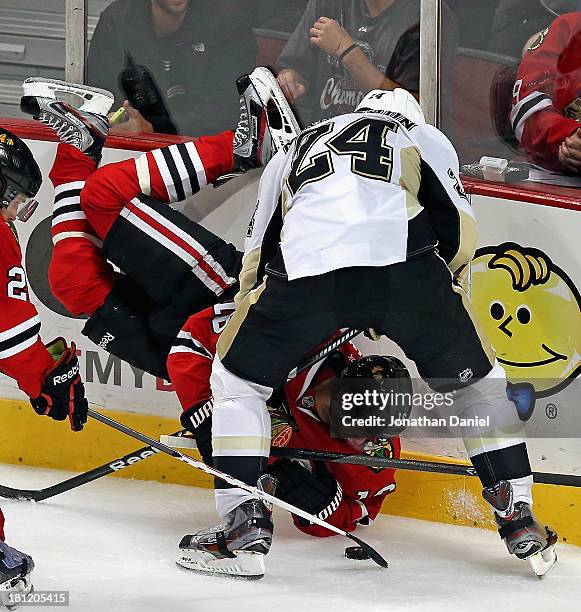 Marcus Kruger of the Chicago Blackhawks flips in the air while battling for the puck with Brendan Mikkelson of the Pittsburgh Penguins during an...