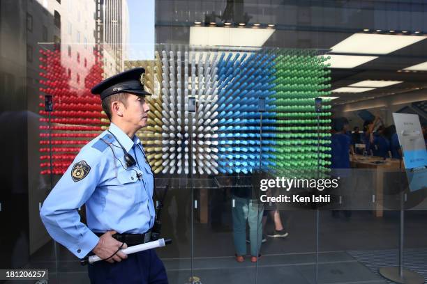 Policemen stands at front of Apple Store in Ginza district on September 20, 2013 in Tokyo, Japan. The company launched the new iPhone 5C model that...