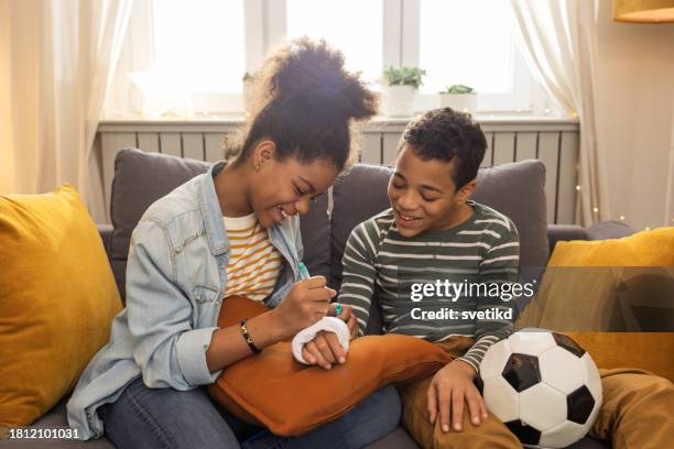 geschwisterbindung zu hause - armbruch stock-fotos und bilder