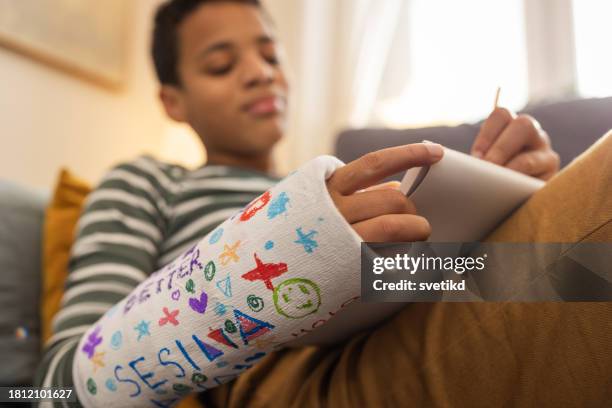junge mit gebrochenen arm - gebrochener arm stock-fotos und bilder