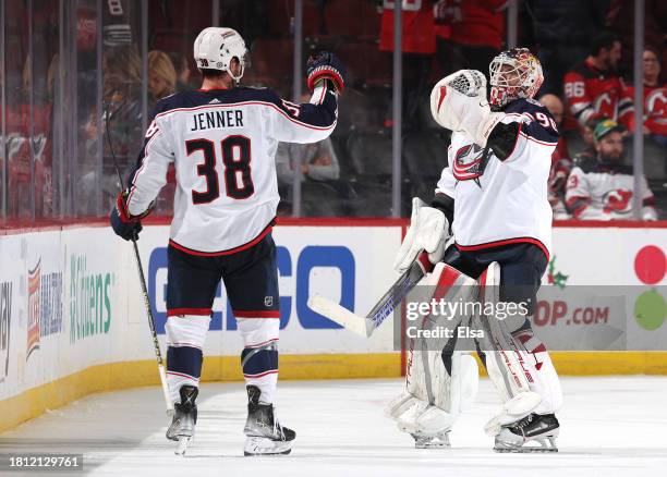 Boone Jenner and Elvis Merzlikins of the Columbus Blue Jackets celebrate the win over the New Jersey Devils at Prudential Center on November 24, 2023...