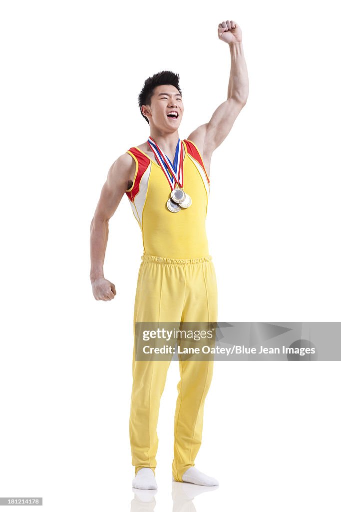 Athlete with medals punching the air for winning
