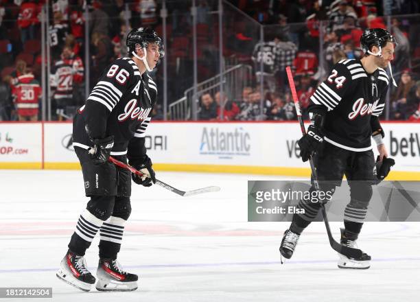 Jack Hughes and Colin Miller of the New Jersey Devils skate off the ice after the loss to the Columbus Blue Jackets at Prudential Center on November...