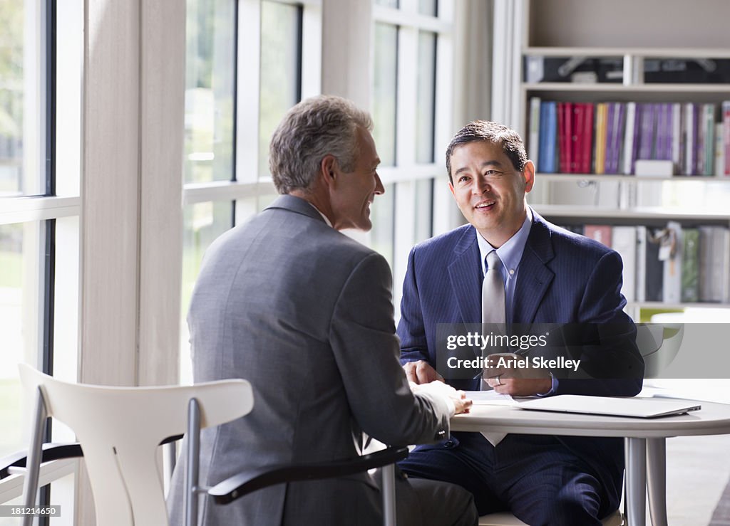 Businessmen talking at desk