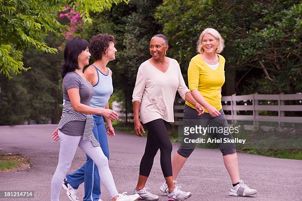 older women walking together outdoors - walking stock pictures, royalty-free photos & images
