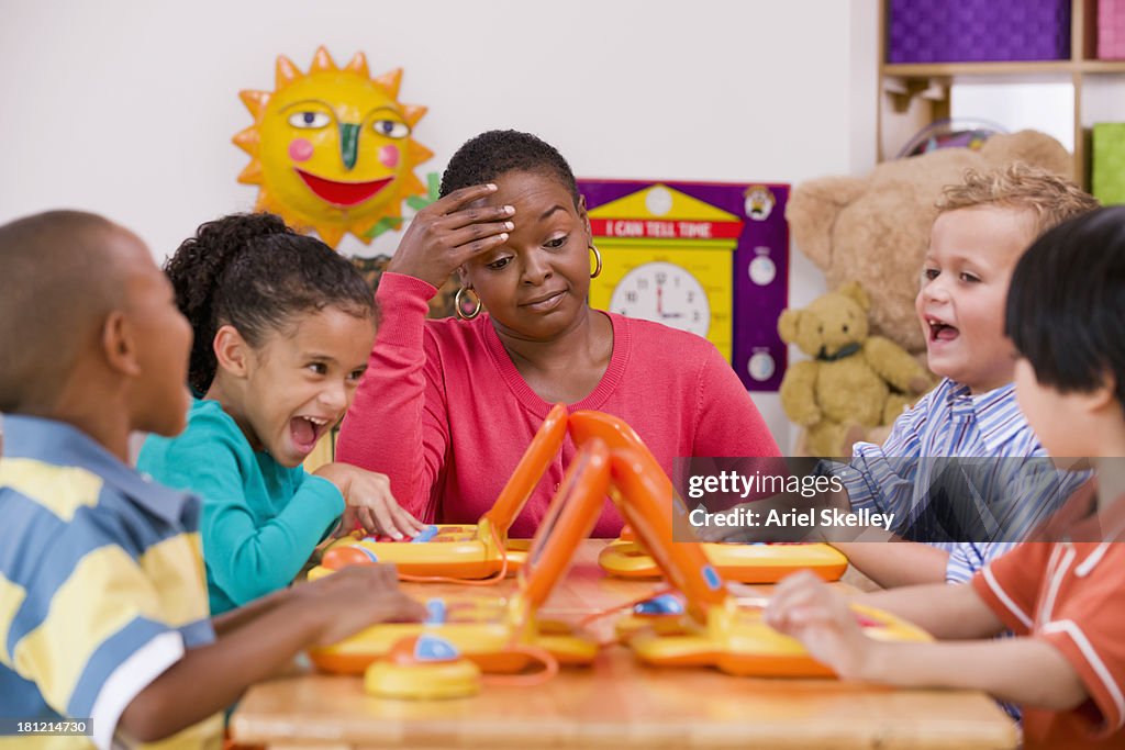 Children playing with toy laptops in class