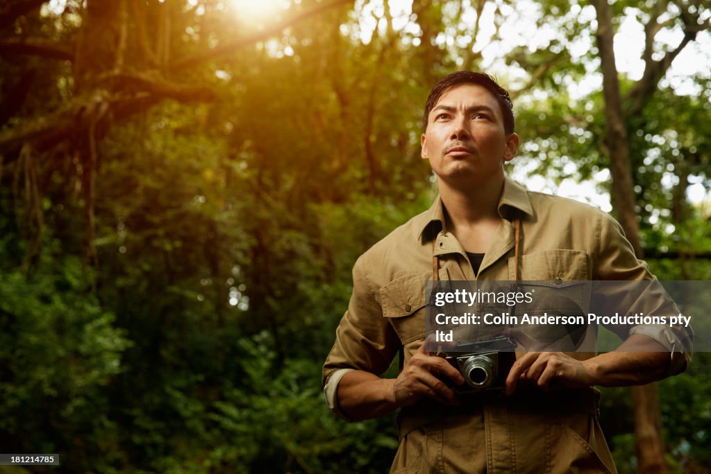 Asian photographer standing in jungle