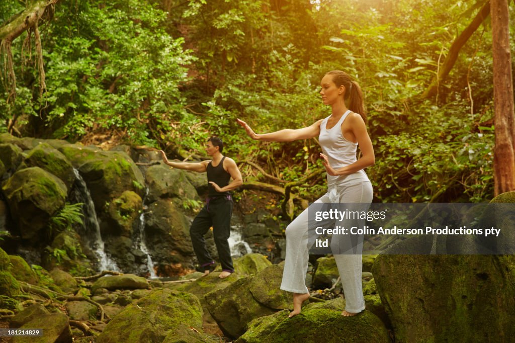 Couple practicing yoga in jungle