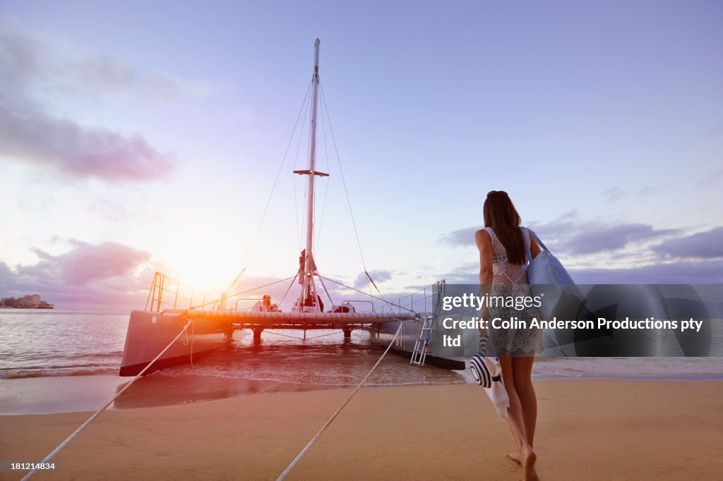 Woman walking to boat on beach