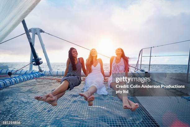 women relaxing on boat in ocean - catamaran race photos et images de collection