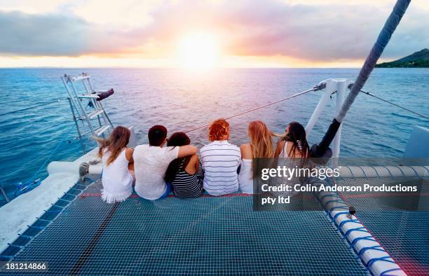 friends relaxing on boat in ocean - catamaran stock pictures, royalty-free photos & images