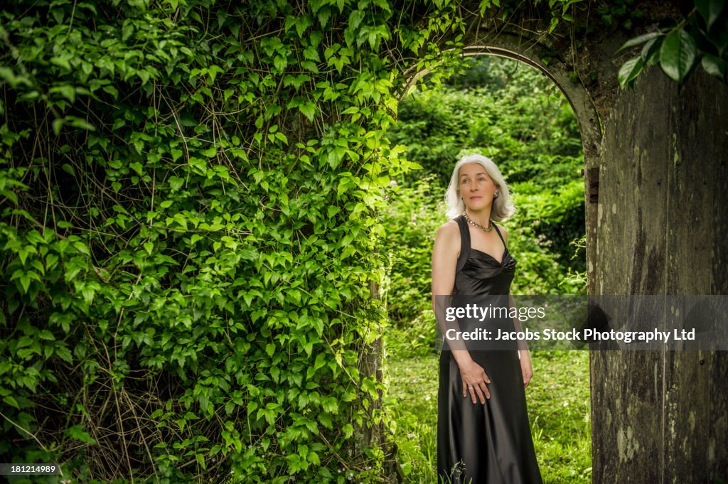 Caucasian woman wearing evening gown in garden