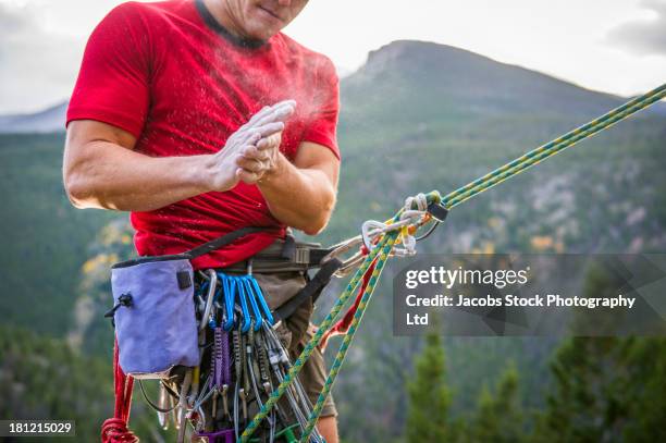 mixed race climber scaling steep rock face - chalk hands stock pictures, royalty-free photos & images