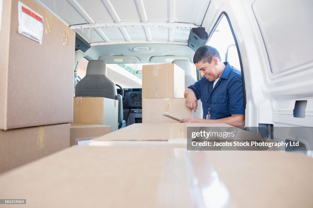 Hispanic deliveryman unloading van