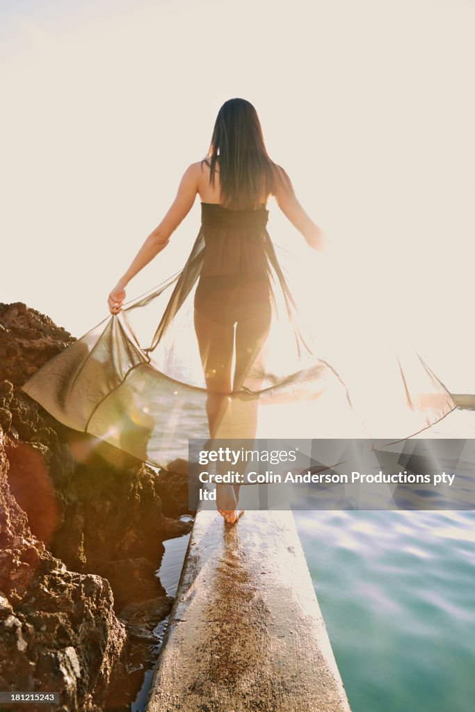 Pacific Islander woman walking on wooden railing